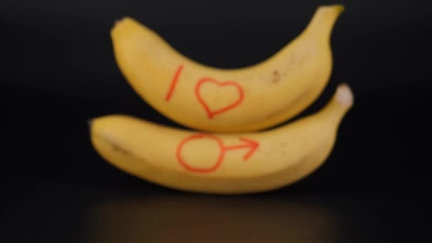 Banán na černém pozadí. Symbol mužnosti, mužské síly. — Stock video