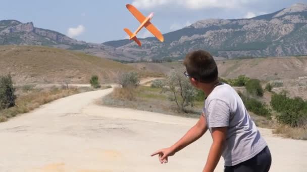 Boy with a toy airplane in his hands on the background of the sea. — Stock Video