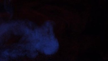 Açık bir sis ve duman içinde mavi ve kırmızı renkli parlak parçacıkların karışımı.