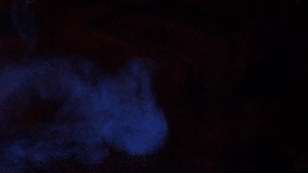 Mélange de particules de couleurs lumineuses de peinture bleue et rouge dans un brouillard léger, fumée. — Video