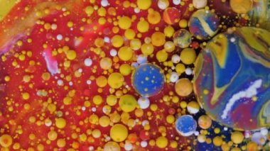 Kırmızı, mavi ve sarı baloncuklar kırmızı arka planda.