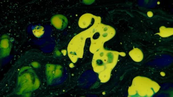Mixing of blue, yellow and green colors in spots and balls on a black three-dimensional moving background, transition. — Stock Video