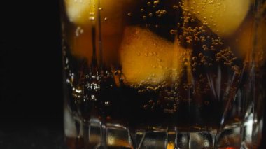 Buzlu bardak soda ile doludur. Buzlu koyu karbonatlı içecekler..