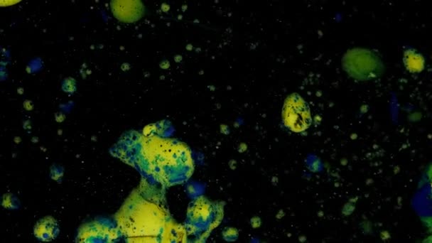 Miscelazione di colori blu, giallo e verde in macchie e palline su uno sfondo nero in movimento tridimensionale, transizione. — Video Stock