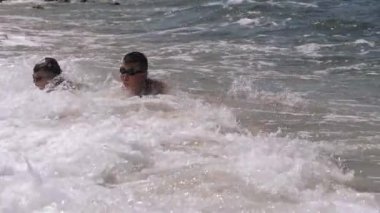 Kıyıdaki deniz dalgaları çocuğun dalmasına neden oluyor..