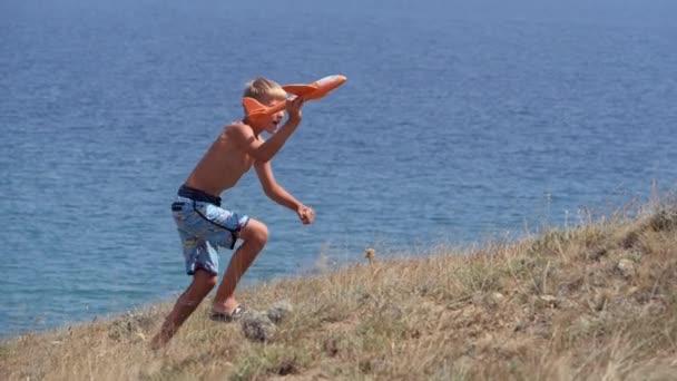 Boy with a toy airplane in his hands on the background of the sea. — Stock Video