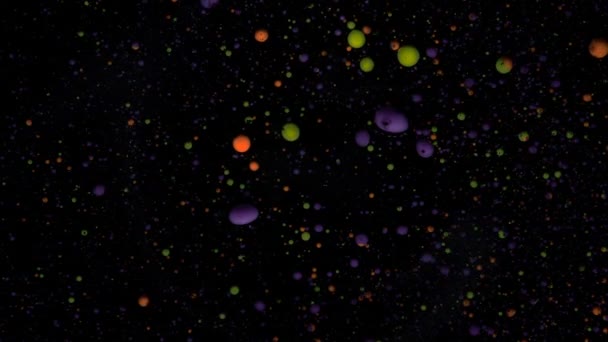 Boules rondes multicolores sur fond noir avec paillettes argentées. Les particules rouges, bleues et vertes se déplacent au hasard. — Video