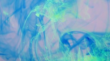 Sıvı pembe bir alanda mavi, yeşil boya yayılıyor..