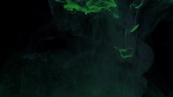 Змішування частинок сяючих кольорів зеленої фарби в диму . — стокове відео
