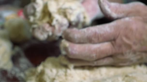 Mains froissées d'un homme âgé pétrir la pâte et faire des boules de kolobok. — Video