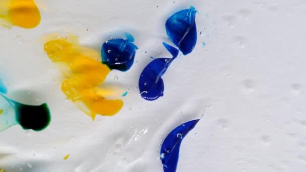 Gotas de azul, amarillo y verde sobre un fondo en movimiento. Textura de gel con burbujas. — Vídeos de Stock
