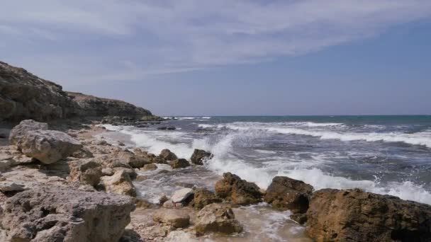 Las olas del mar rompen en las rocas costeras. — Vídeos de Stock
