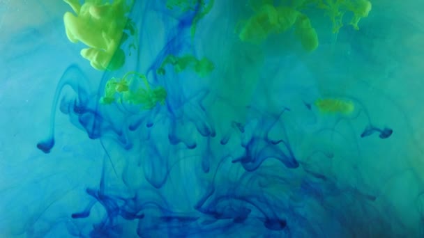 Épandage de peinture bleue et verte dans un espace liquide. — Video