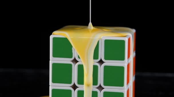 Куб у барвистій різнокольоровій фарбі. Акриловий потік навколо тривимірної фігури. — стокове відео