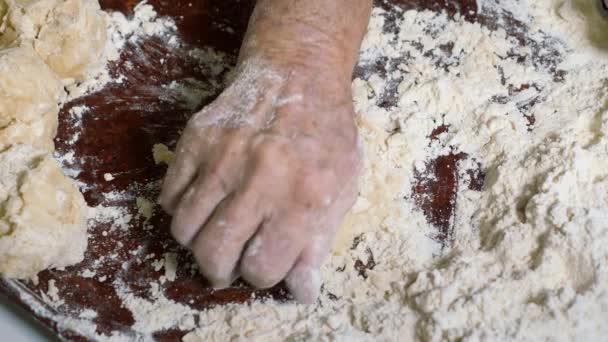 Морщинистые руки пожилого человека месить тесто и сделать шары колобок. — стоковое видео