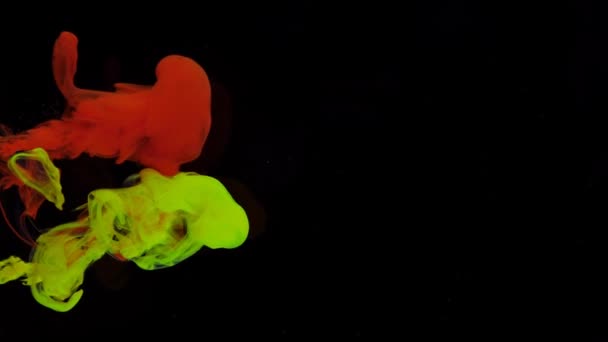 빨강 과 노랑 페인트 의 흐름은 검은 배경 위의 투명 한 공간에서 녹는다. — 비디오