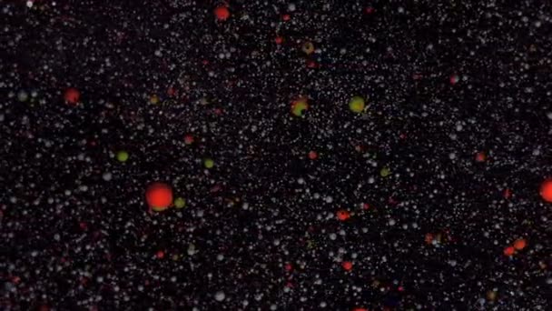 Les particules blanches et rouges se déplacent au hasard. Noël, Nouvel An économiseur d'écran. Boules rondes multicolores sur fond noir avec paillettes argentées. — Video