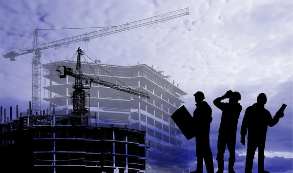 Silhouettes of builders on a background of houses under construction — Stock Photo, Image