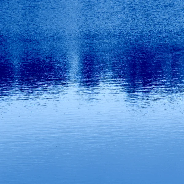 Гладкая поверхность воды с отражением — стоковое фото
