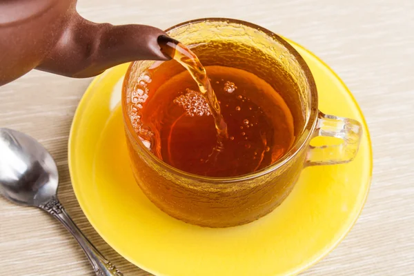 Tea being poured into tea cup with saucer — Stock Photo, Image