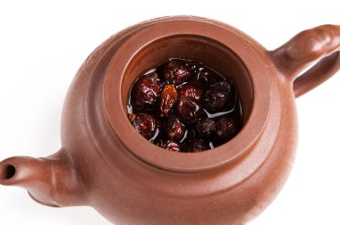 Dry resehip brew in pottery teaopot clipart