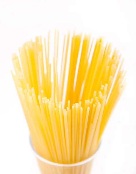 Longo macarrão amarelo seco em vidro — Fotografia de Stock