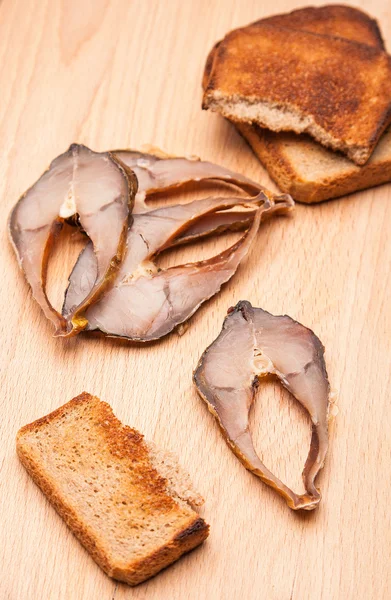 Toast from bread with pieces smoked fish — Stock Photo, Image