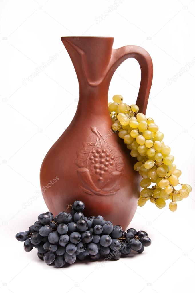traditional clay jug for wine with bunch grapes