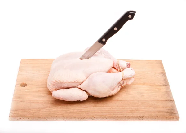 Pollo sin cocer con cuchillo sobre tabla de madera — Foto de Stock