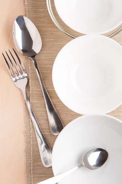 Білі миски та посуд на серветці та дереві — стокове фото