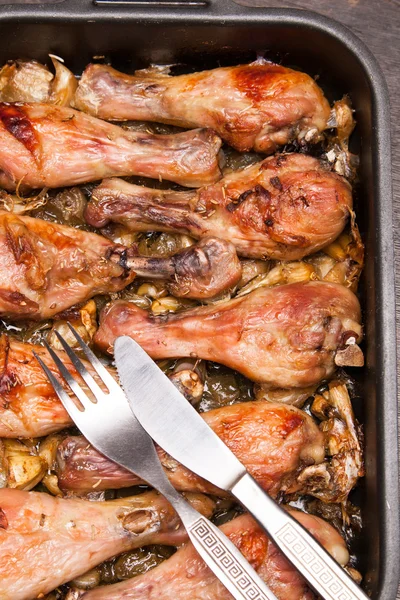 Pernas de frango assadas na bandeja em madeira preta — Fotografia de Stock