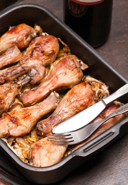 Baked chicken legs in tray on black wooden — Stock Photo, Image