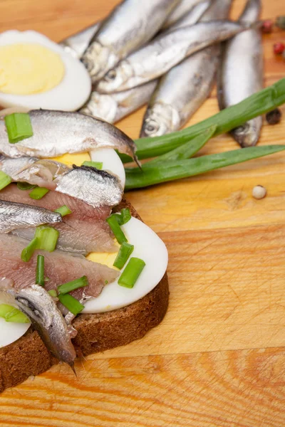 Sandwich from salted anchovies with egg and spring onion — Stock Photo, Image