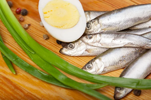 Salted anchovies, egg, and spring onion on wooden — Stock Photo, Image