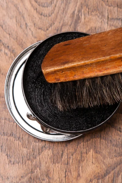 Container of shoe polish and brush on wooden — Stock Photo, Image