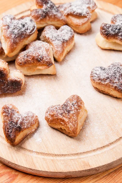 Bageri hjärtan från split bakverk med socker pulver på trä — Stockfoto