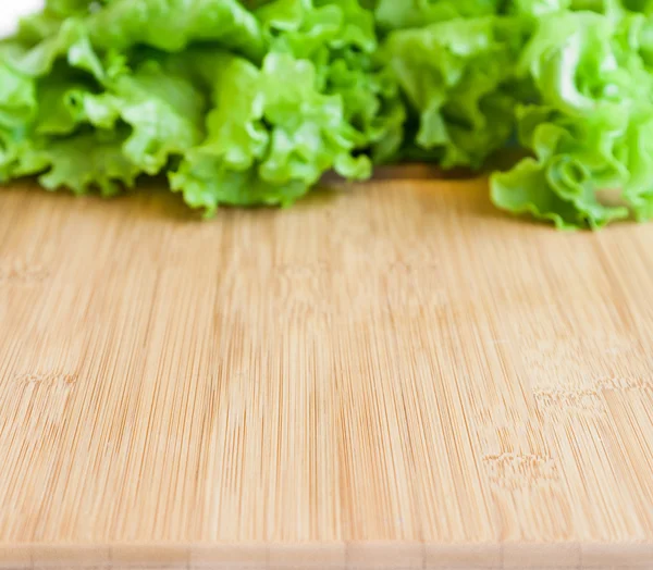 Background with wooden board and leaf lettuce — Stock Photo, Image