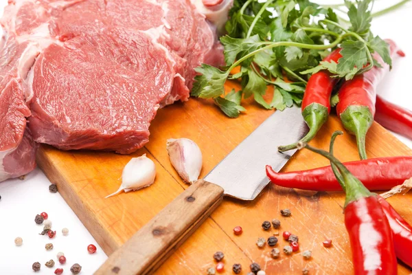 Świeże mięso wołowiny z kością na drewniane przyprawy i nóż — Zdjęcie stockowe
