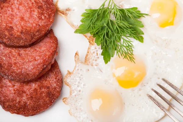 Frühstück mit Spiegeleiern und Wurst auf Teller — Stockfoto