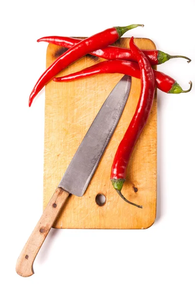 Hot capsicum chili pepper and knife on board — Stock Photo, Image