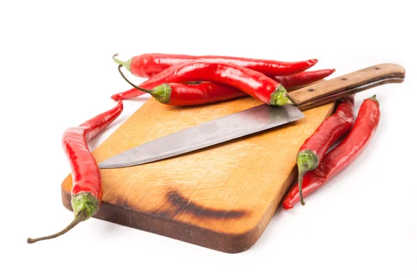 Hot capsicum chili pepper and knife on board — Stock Photo, Image