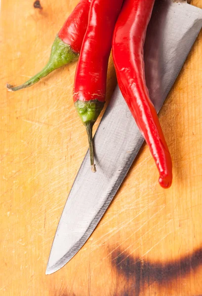 Varm paprika chilipeppar och kniv ombord — Stockfoto