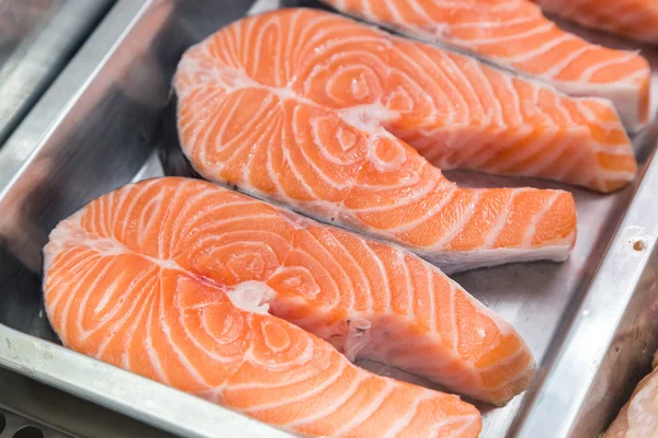 Filetes de salmón crudos en placa metálica en escaparate —  Fotos de Stock