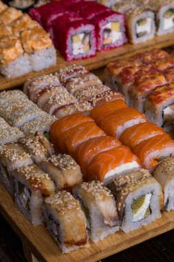Muhtelif suşi ve koyu ahşap tahta üzerinde rulo