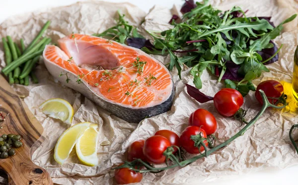 Filete de salmón fresco sobre papel marrón triturado con guarnición —  Fotos de Stock
