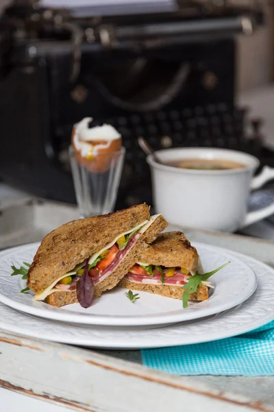 Frühstück aus Toastbrot, gekochtem Ei und Tee auf Schreibmaschinenrücken — Stockfoto