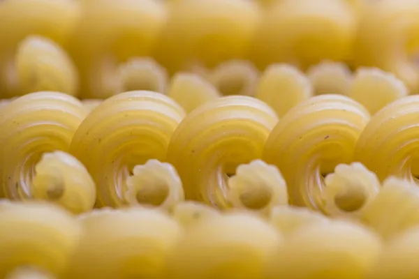 Ribbed dry yellow macaroni with periodic line — Stock Photo, Image