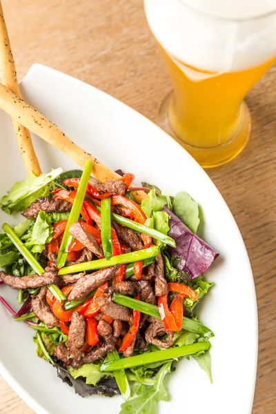 Plaat van salade van vlees met groenten en lichte Beer — Stockfoto
