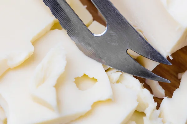 Plátky maasdam bílý sýr s nožem — Stock fotografie