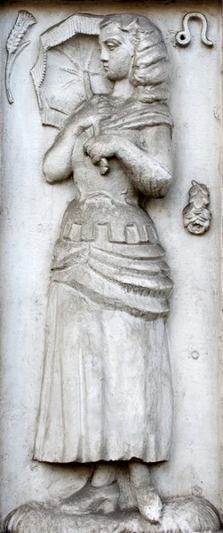 Old vintage bas-relief with woman holding the umbel Stock Photo